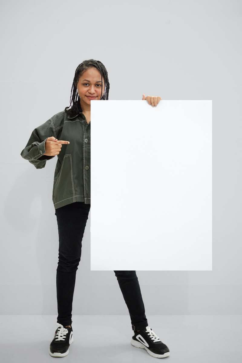 white paper woman in green jacket holding white paper mockup